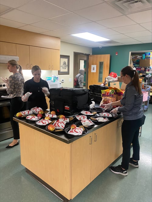 Verger Capital team members serve lunch to students at the Winston Salem Street School
